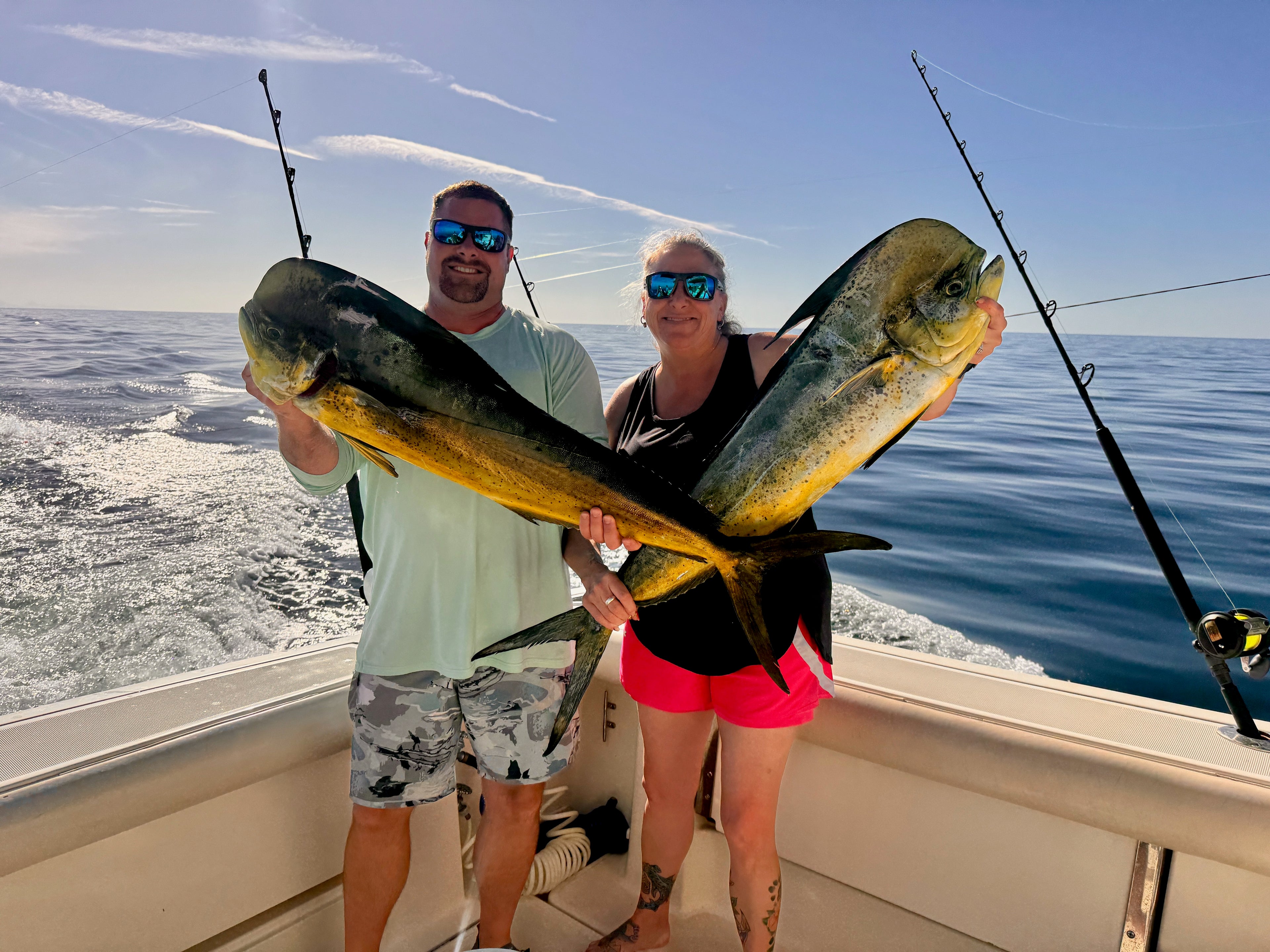 two people holding mahi mahi fish
